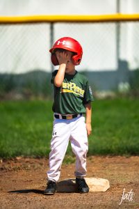 candid photos of a kid facepalming from baseball